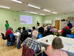 tenants sat around tables at tenants voice as waste management explain the new recycling concepts 